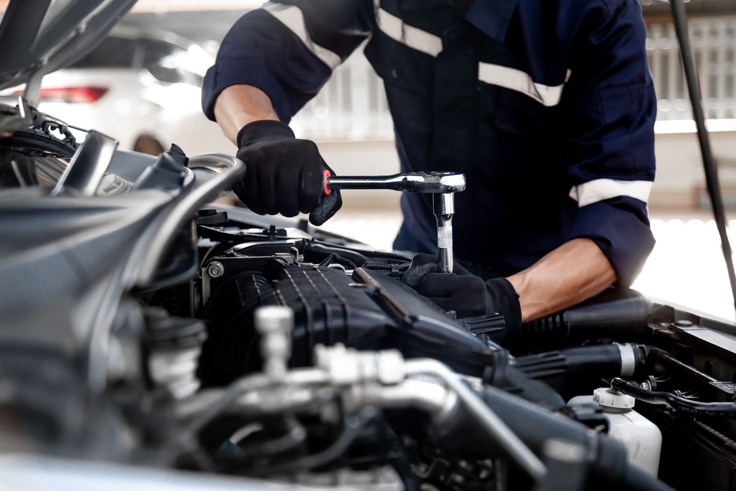 Mechanic servicing a vehicle engine.