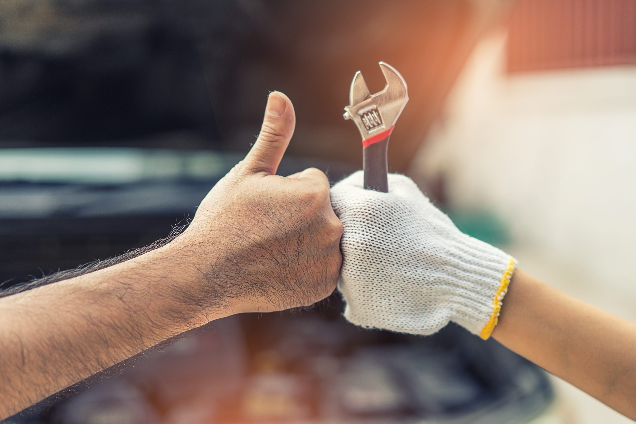 Customer approves vehicle service with mechanic holding a wrench