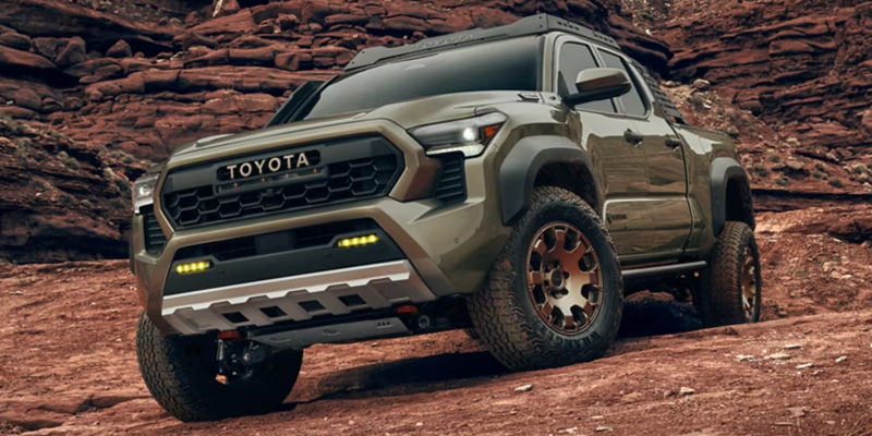 Toyota Tacoma pickup truck parked on a rocky off-road desert trail.