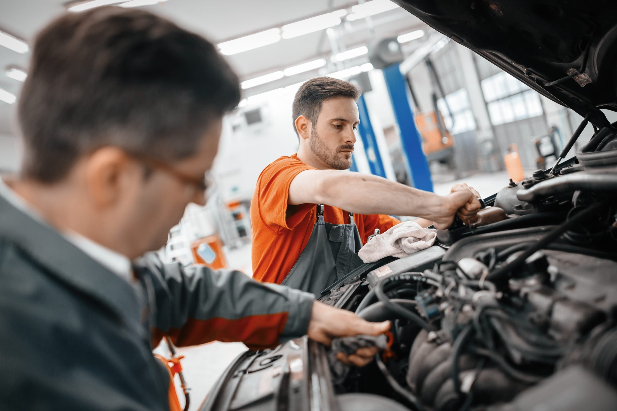 Mechanics inspecting a vehicle engine